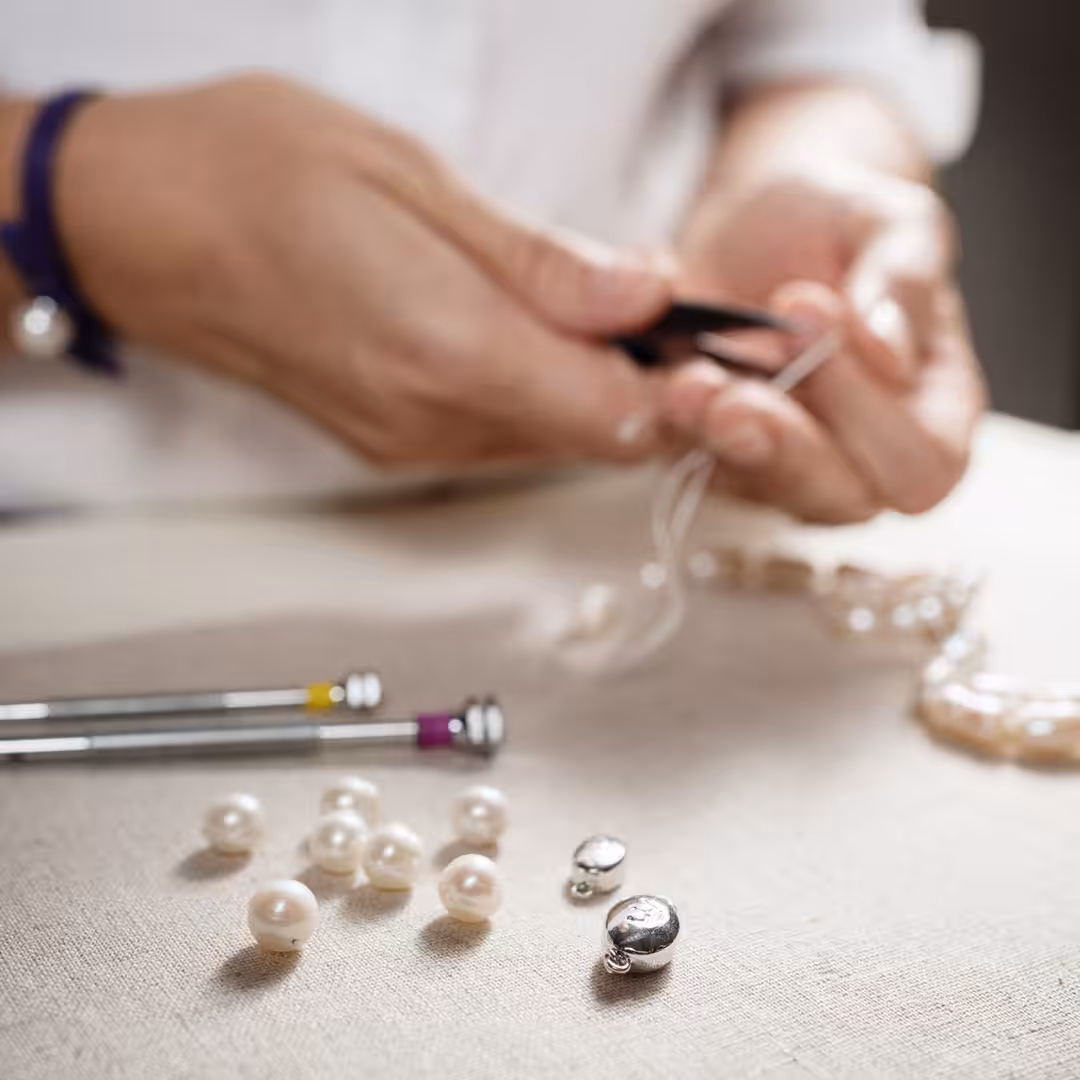 Jewellery designer stringing pearls
