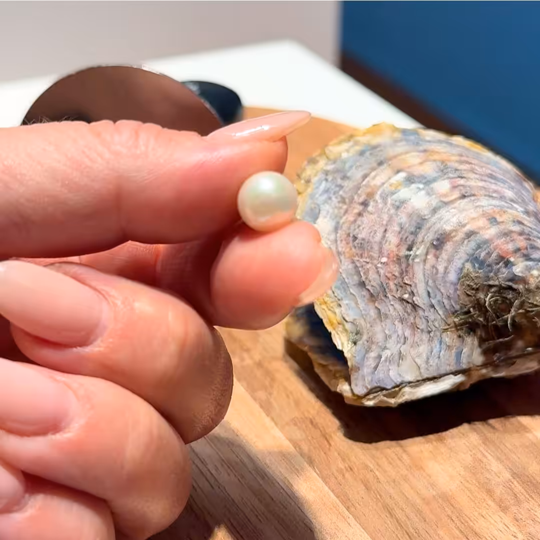 customer holding a pearl from their pick a pearl experience